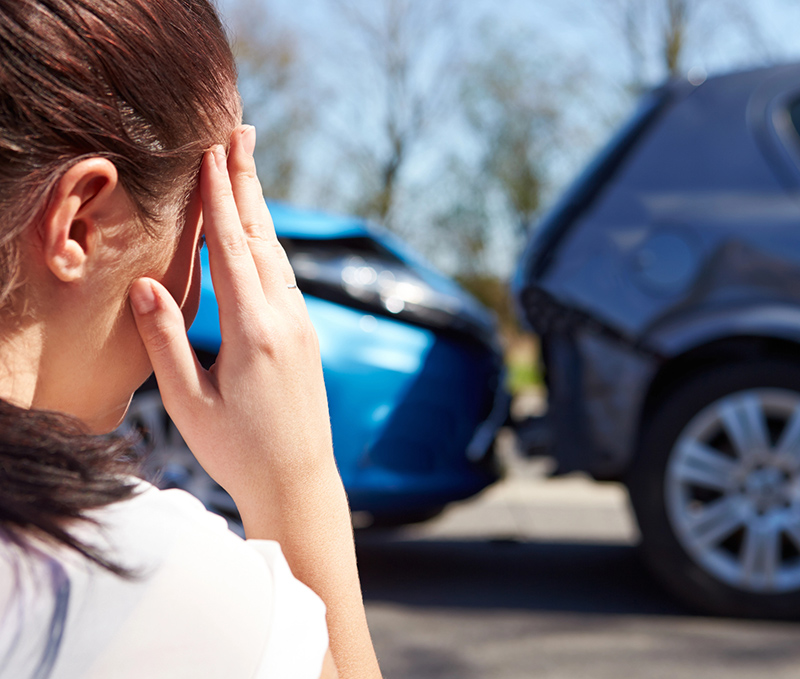 Driver overwhelmed after a vehicle collision, showing the importance of auto coverage