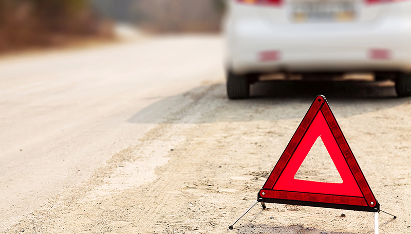 Reflective safety triangle warning of a stopped vehicle on the road